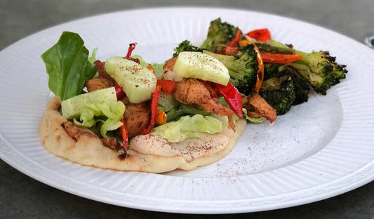 Oven-baked chicken shawarma with naan, hummus and fresh vegetables