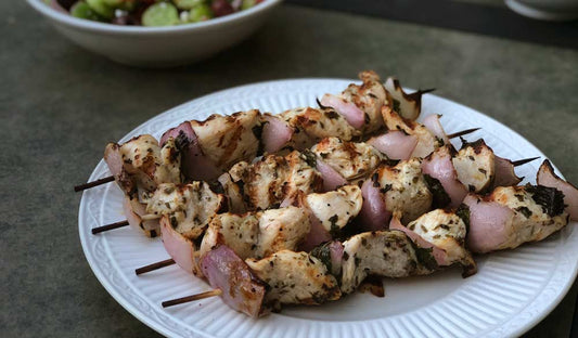 Grilled Greek chicken kebabs with red onion and fresh mint