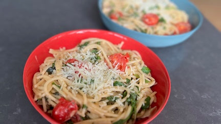 Spaghetti with arugula, cherry tomatoes, and creamy basil sauce